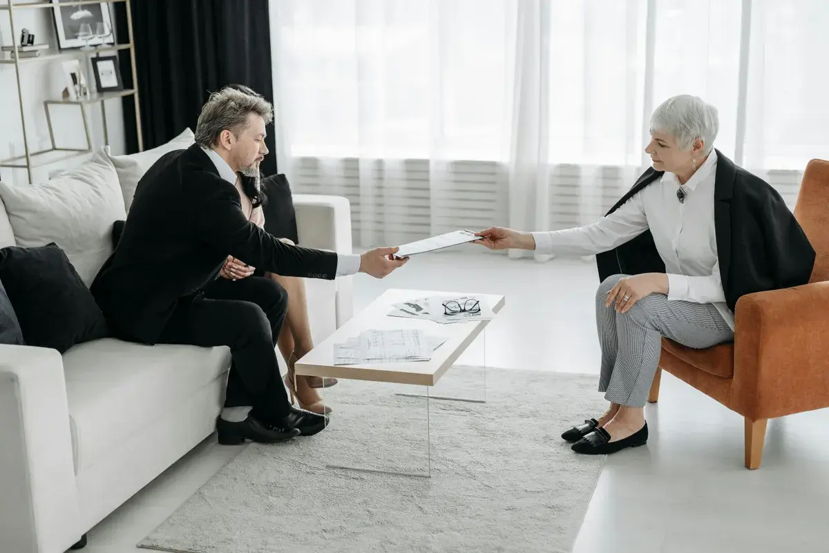 Mortgage broker handing her fees to a couple client