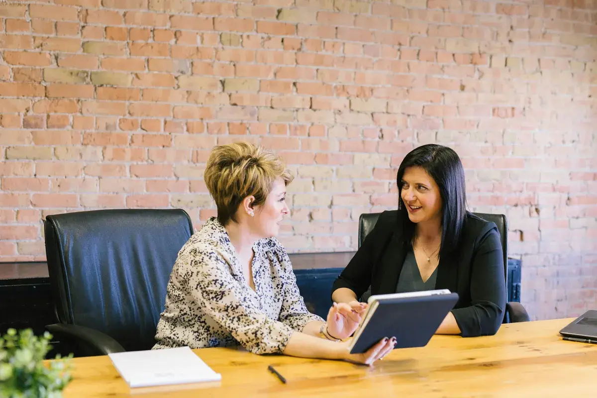Two women talking about loan vs. mortgage