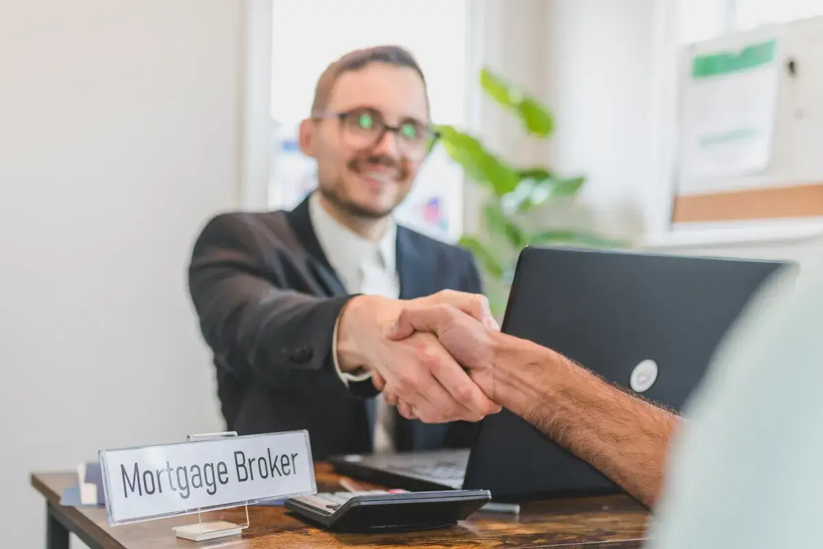 A mortgage broker shaking hands with his new client