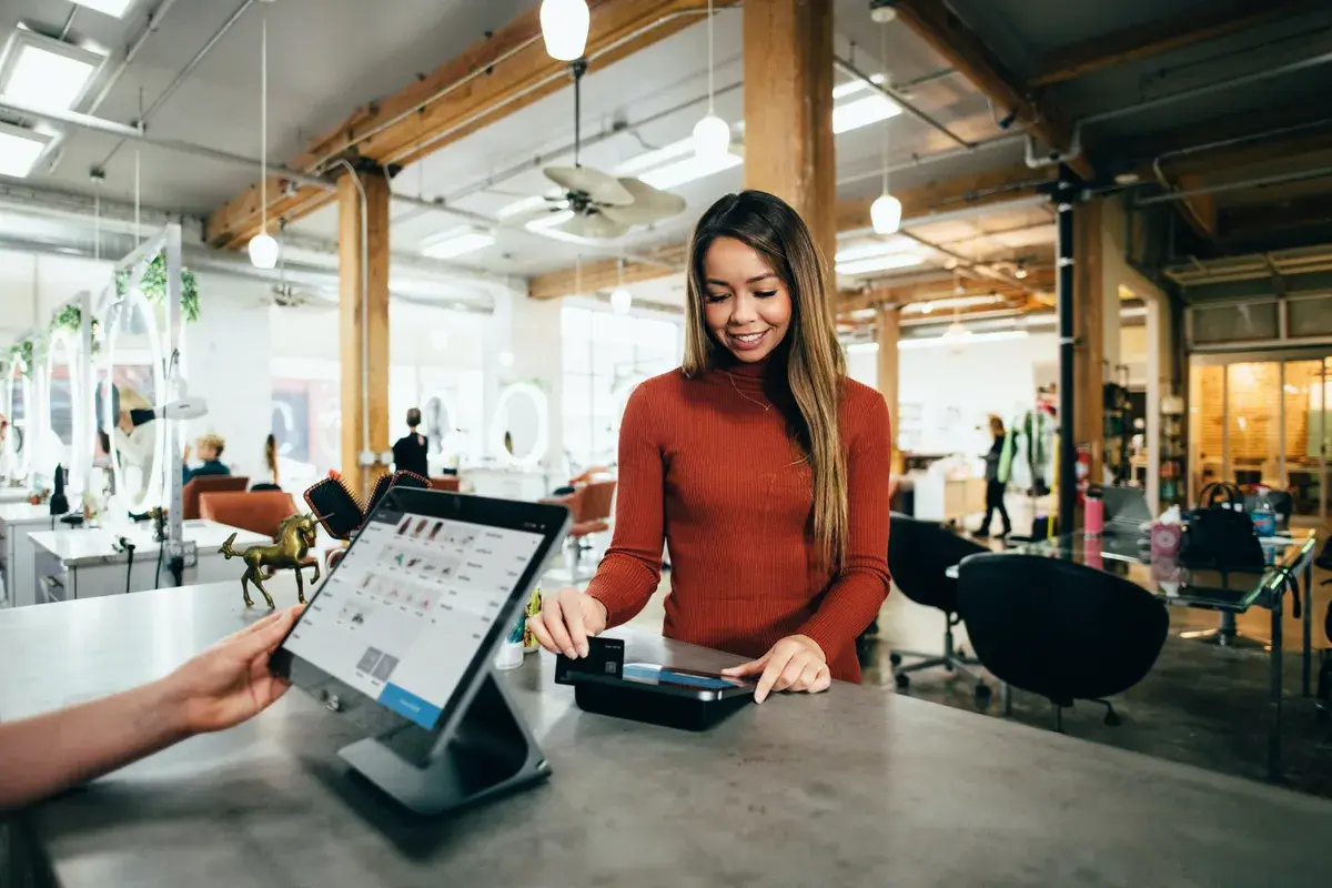 Woman with a good credit score swiping her credit card