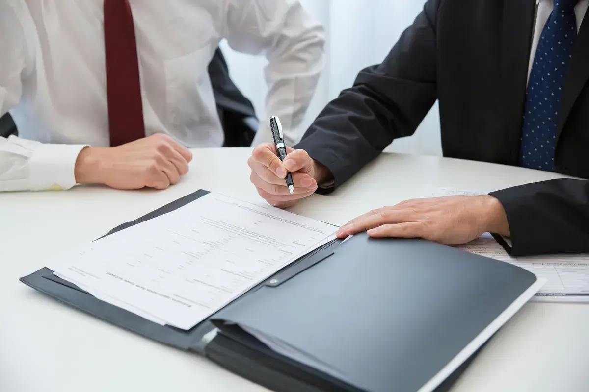 Businessman signing contract beside a gurantor