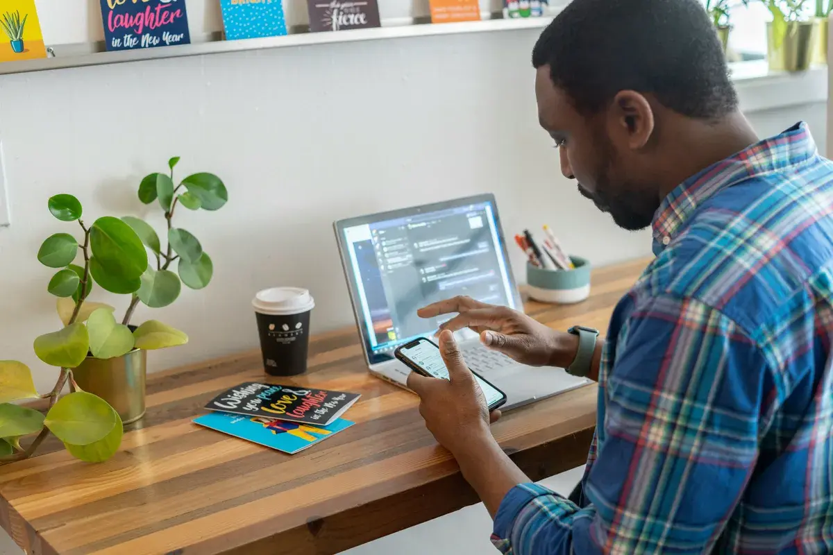 Man using phone and laptop researching what secrets to keep from lenders